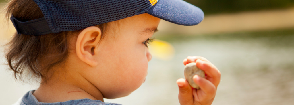 Toddler holding a small stone