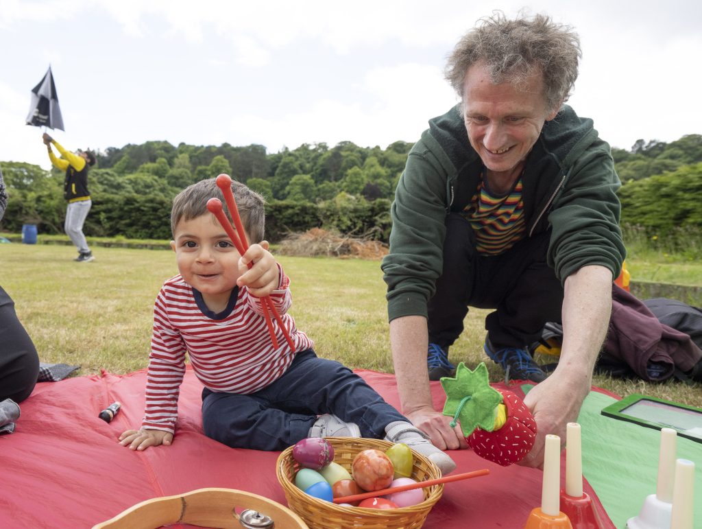 a playworker facilitates musical interactions