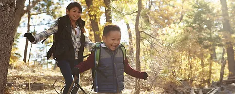 Two children playing in the woods